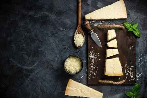 Top view of triangular piece of hard cheese on wooden cutting board Stock Photos