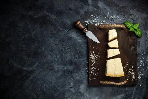 Top view of triangular piece of hard cheese on wooden cutting board Stock Photos