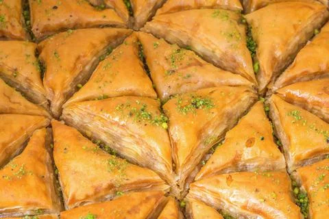 Top view of triangular-shaped almond baklava with pistachio toppings 库存照片