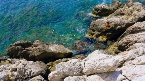Top View of Turquoise Clear Waves Crashing on Light Beige Rocky Cliffs Stock Footage 309466555