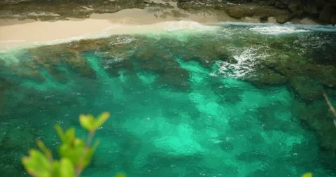 Top view turquoise ocean water washing over rocky seabed near white sand beach Stock-Footage 327455396