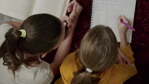 Top View Tutor Helping Little Girl With Her School Homework Stock Footage 126047659