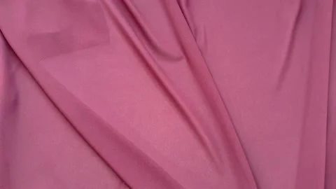 Top view of twisted pink silk fabric for sewing and needlework Stock Footage 306561051