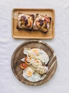 Top view of two breakfast plates with cinnamon rolls and eggs in white shir.. Foto stock