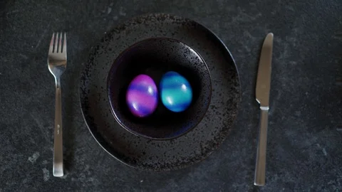 Top view of two colorful Easter eggs on a black plate on a dark background 库存影片 116416924