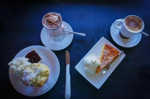 Top view of two cups of coffee with scone with whipped cream and cake Stock Photos