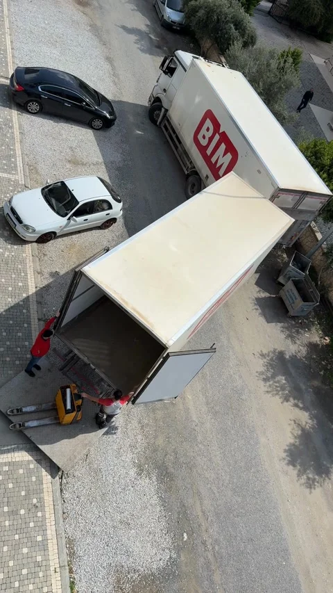 Top view of two delivery trucks with open doors and people unloading goods Stock Footage 336273474