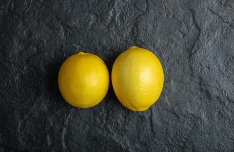 Top view of two fresh ripe lemon on black background. Close up photo Stock Photos