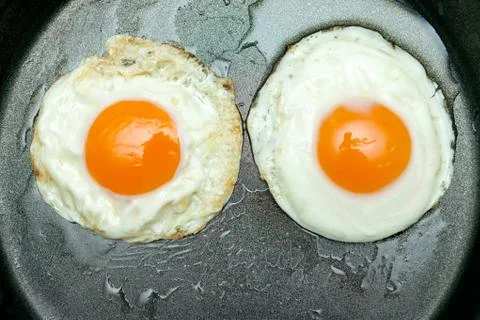 Top view of two fried egg in a pan Stock Photos