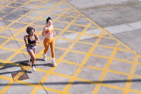 Top view of two friends running along city road Stock Photos