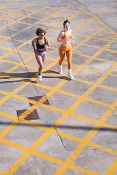 Top view of two friends running along city road Foto stock