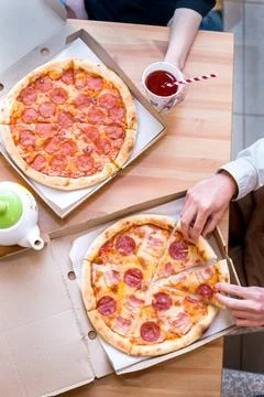 Top view of two friends students meeting and eating pizza together Stock Photos