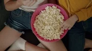 Top View Two Girls Eating Pop Corn From Pink Bowl Stock Footage