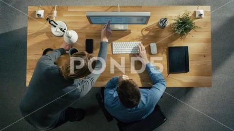 Top View of Two Graphic Designers Discussing Work on Desktop Computer. Stock Photos