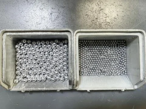 Top view of two gray plastic boxes filled with steel balls of various diameters Stock Photos
