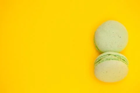 Top view of two green macaroons over yellow background Fotos Stock