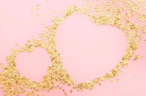Top view two hearts shaped from golden sparkles on pink background. Romantic Stock Photos