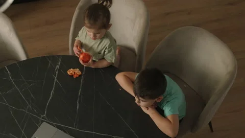Top view of two kids having healthy breakfast sitting at table in modern kitchen Stock Footage 236949862