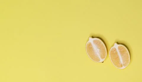Top view of two lemon halves on yellow background Stock Photos