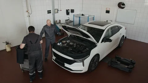 Top View of Two Mechanics Doing Maintenance Work on Car Engine Stock Footage 329408477