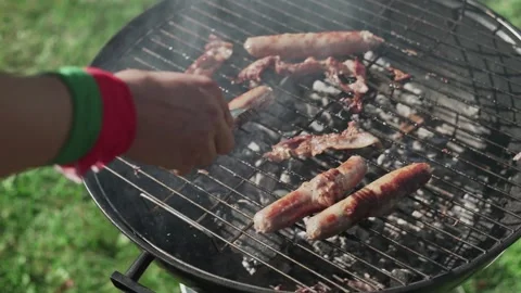 Top view of two men cooking grilling bacon and sausages on bbq grid Stock Footage 143474319