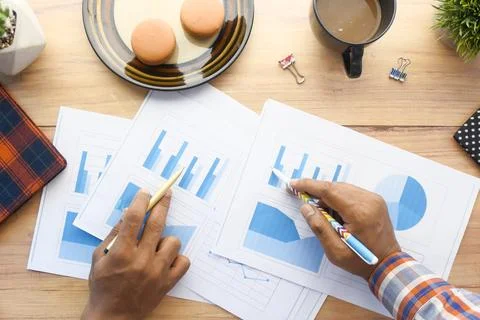 Top view of two people analyzing financial chart on paper Stock Photos