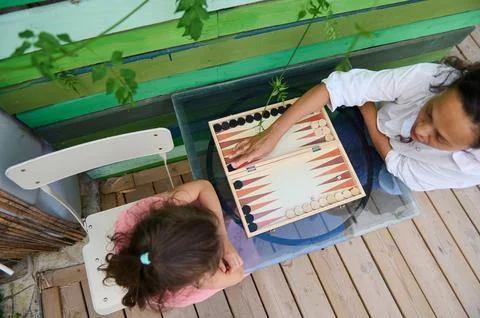 Top view of two people playing backgammon in a bright outdoor setting Stock Photos