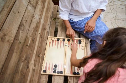 Top view of two people playing backgammon outdoors on a wooden bench Stock Photos
