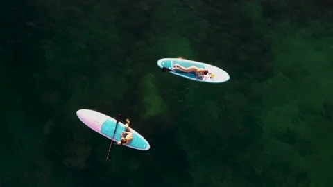 Top view of two people relaxing in the sea on SUP boards Stock Footage 170657126