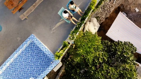 Top view of two people sitting on the rooftop and reading book. Video stock 102187062