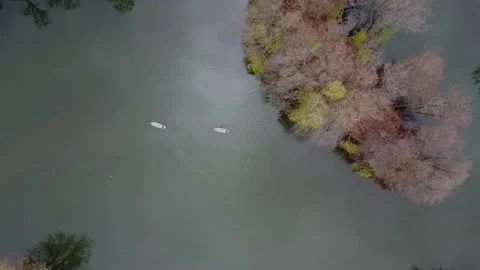 Top view of two people on sup boars floating on the lake through flooded trees Stock Footage 153402371