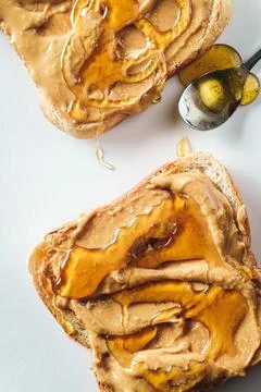 Top view of two pieces of toast with peanut butter and honey spread on top Stock Photos