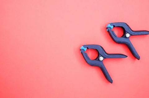 Top view of two plastic spring clamp tools isolated on red background Photos