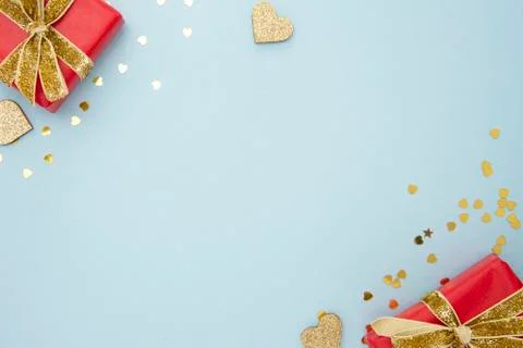 Top view of two red gift boxes with golden sparkling ribbon and golden confet Stock-Fotos