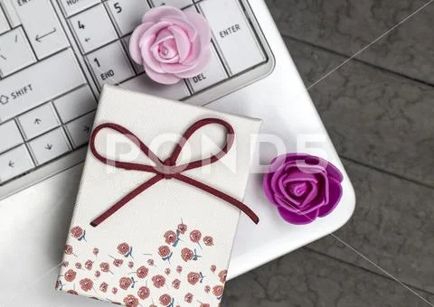 Top view of two roses and white laptop on background. Stock Photos
