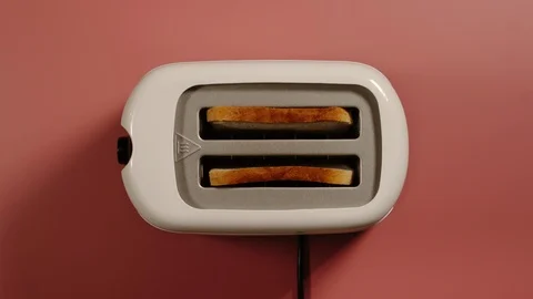 TOP VIEW: Two slices of bread jump out from a toaster on a pink surface Vídeo Stock 120769276
