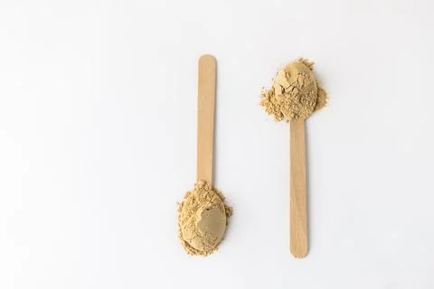 Top view of two spoons with maca root powder on white background 库存照片