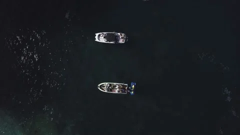 Top view of two standing motor boats and jet skis around them on emerald beach Video stock 135227001