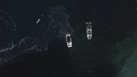 Top view of two standing motor boats and jet skis around them on emerald beach Stock Footage 135227195