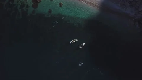 Top view of two standing motor boats and jet skis around them on emerald beach Stock Footage 135227558