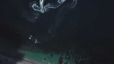Top view of two standing motor boats and jet skis around them on emerald beach Stock Footage 135227718