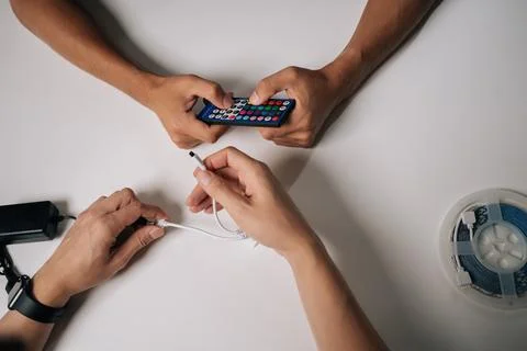 Top view of two technicians connecting RGB led strip lights using remote control Stock Photos
