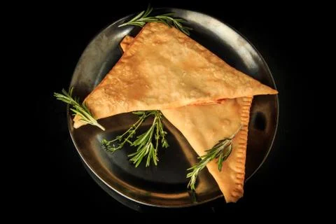 Top view of two triangles of caucasian chebureki with green rosemary 写真素材