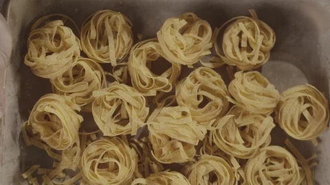 Top view uncooked noodle nest in slow motion flying up Stock Footage 114307593