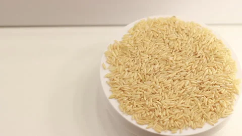 Top view on uncooked whole grain brown rice seeds circle rotation. Copy space, p Stock Footage 264831244