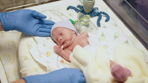 Top view of unrecognizable doctor in white gloves carying at neonatal intensive Stock Footage 253727787
