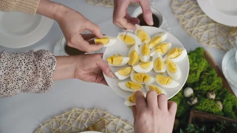 Top view of unrecognizable family sharing with egg during easter dinner Stock Footage 170876136