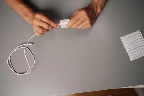 Top view of unrecognizable man connecting USB cable to electronic cigarette Stock Photos