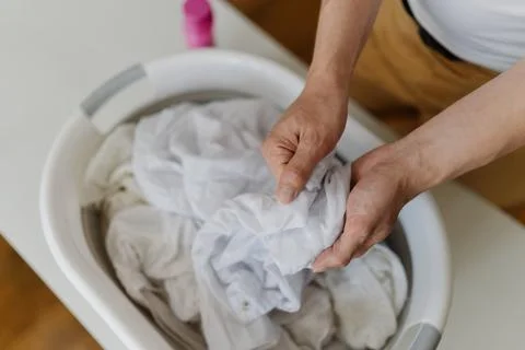 Top view of unrecognizable man preparing white clothes for washing, soaking in Stock Photos