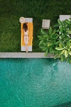 Top view of unrecognizable slim young woman in beige bikini relaxing and 스톡 사진